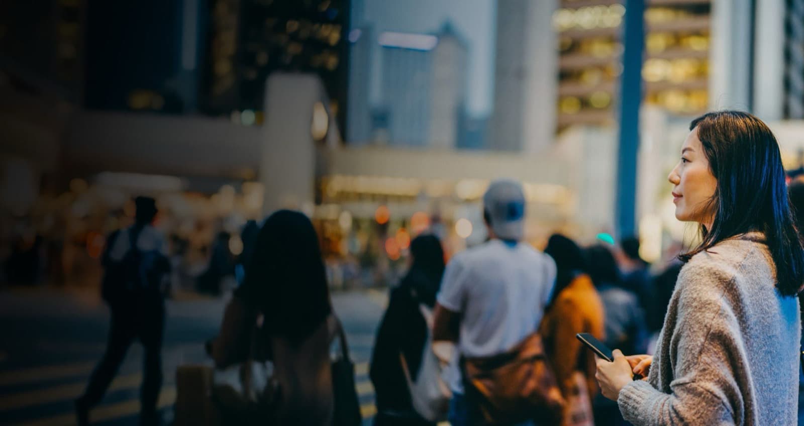 Woman holding her phone in the city