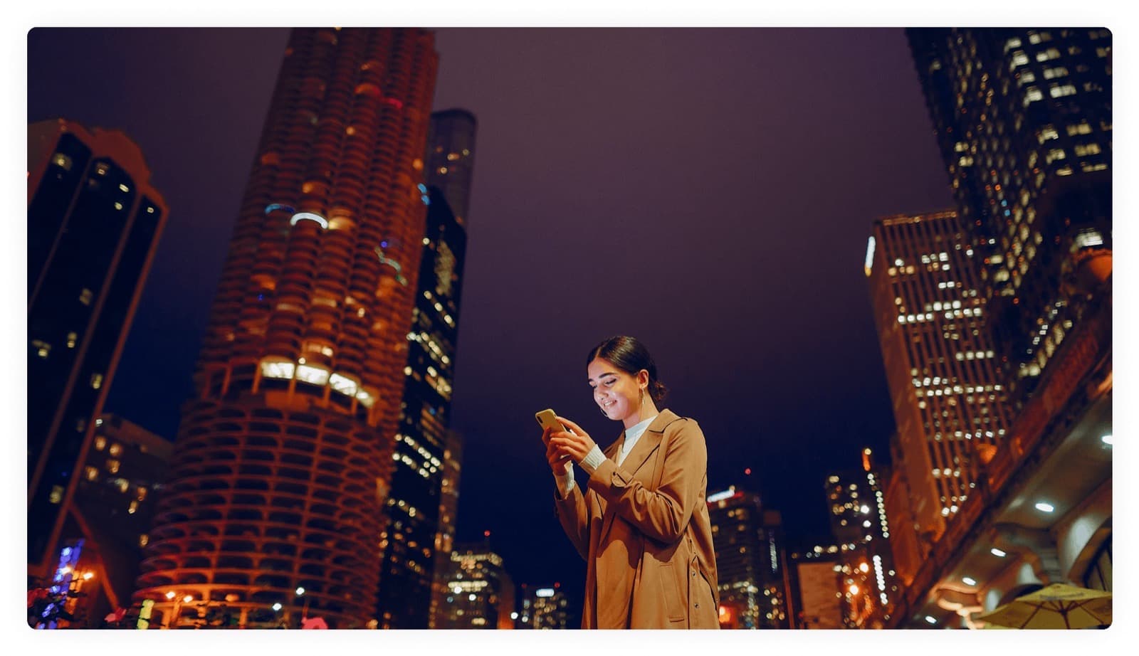 Woman using her phone in a busy city